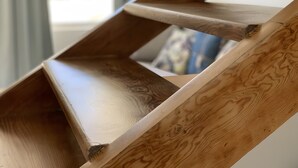 Een houten trap met een uniek ontwerp, leidend naar een verdieping.
