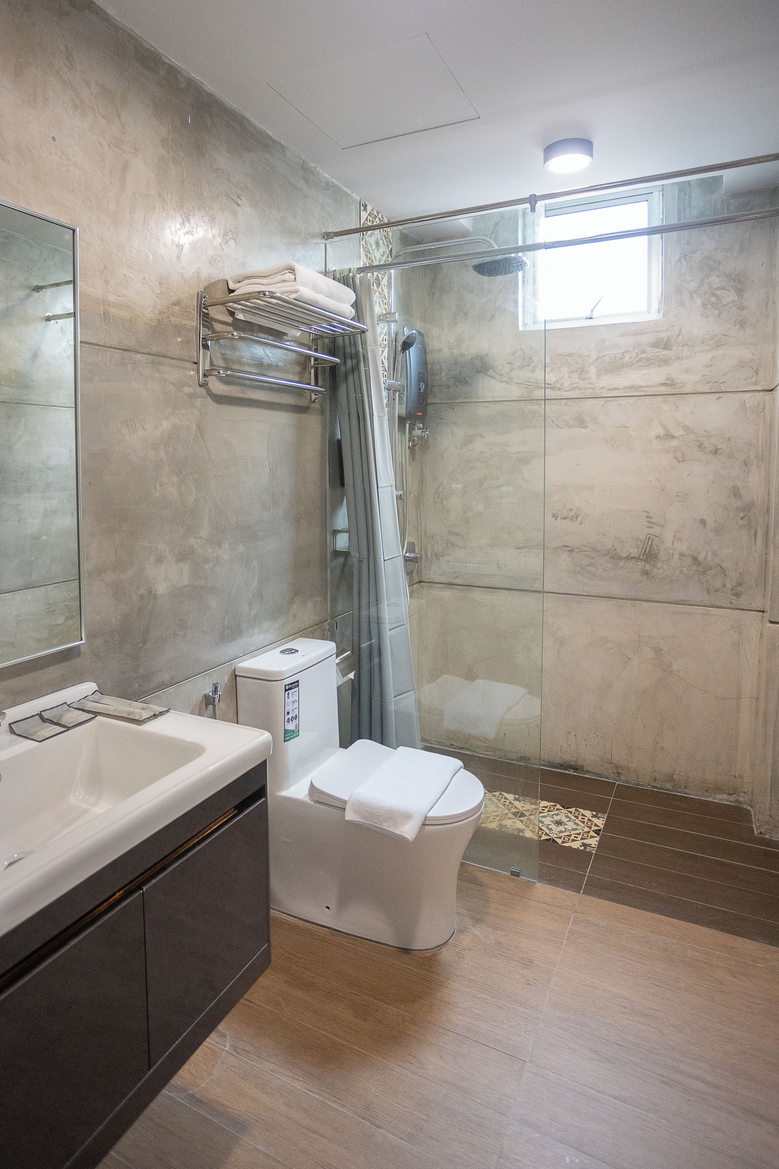 Ein Badezimmer mit Dusche, Toilette, Waschbecken und Spiegel.