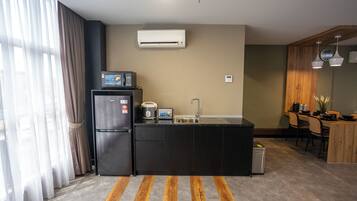 Una cocina compacta equipada con refrigerador, microondas, tostadora y lavadero.