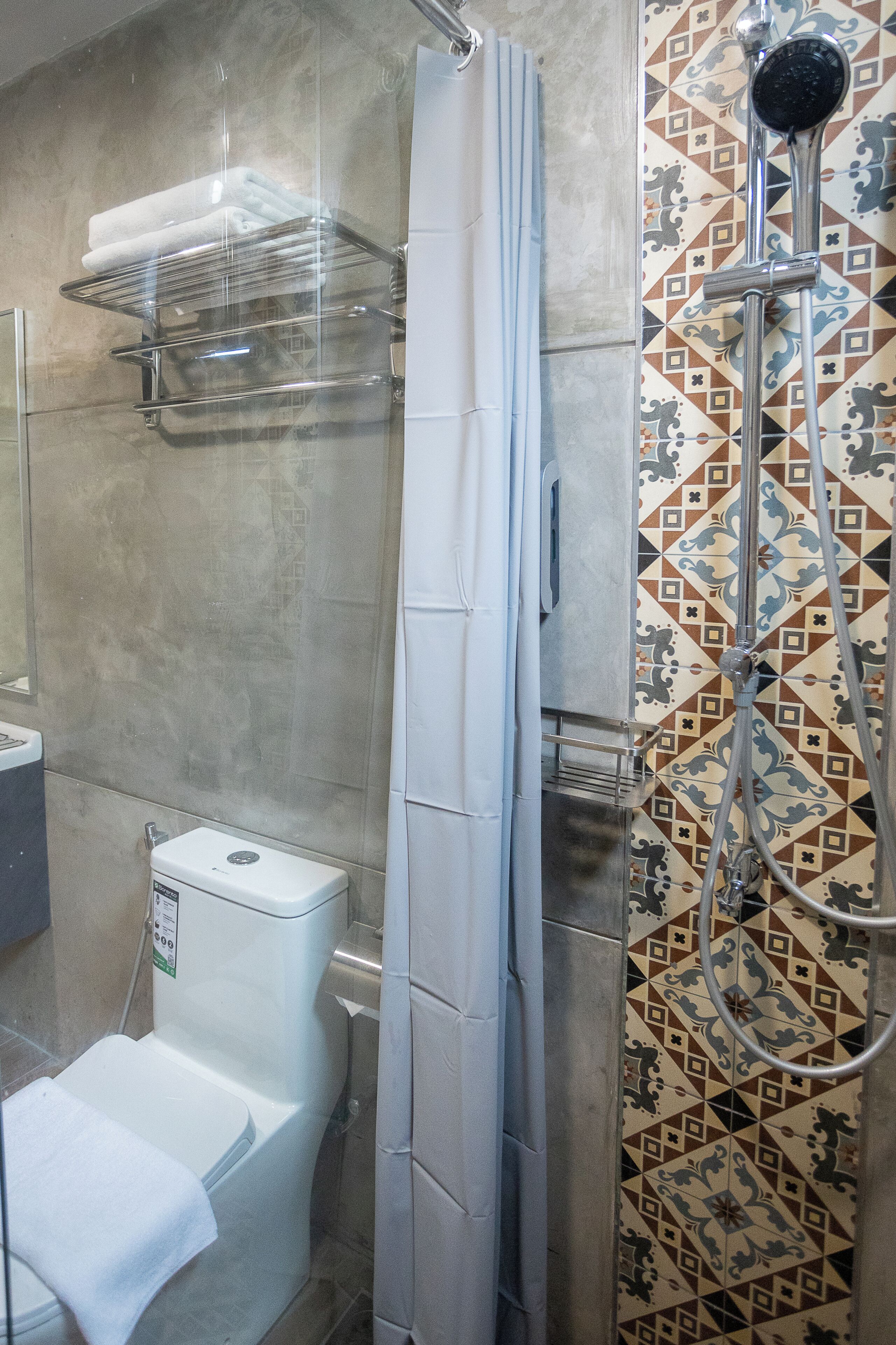 Box de chuveiro com chuveiro e parede revestida de azulejos.