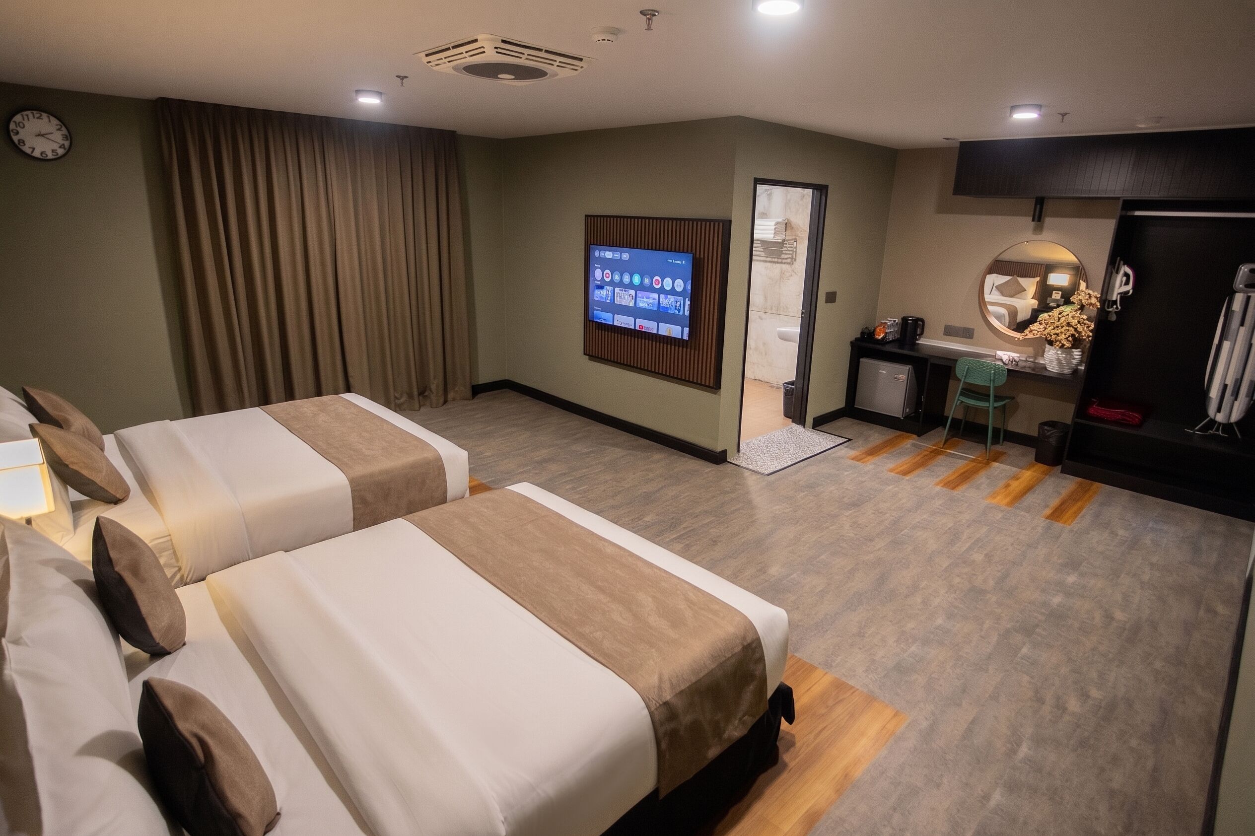 Una habitación de hotel con dos camas, un escritorio, un televisor y un baño.