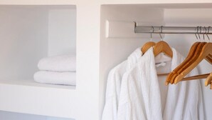 Une salle de bain équipée d’un porte-serviettes, d’un peignoir blanc et d’un coffre-fort noir.