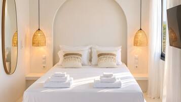 A modern bedroom with a large bed, two bedside lamps, and a large mirror.