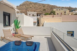 A rooftop terrace with a pool, lounge chairs, and a view of the surrounding buildings and hills. - Majestic View Villa Studio with Sea View and Jacuzzi (Arkasa)