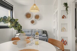A dining area with a round table, a bottle of wine, and decorative plates. - Majestic View Villa Studio with Sea View and Jacuzzi (Arkasa)
