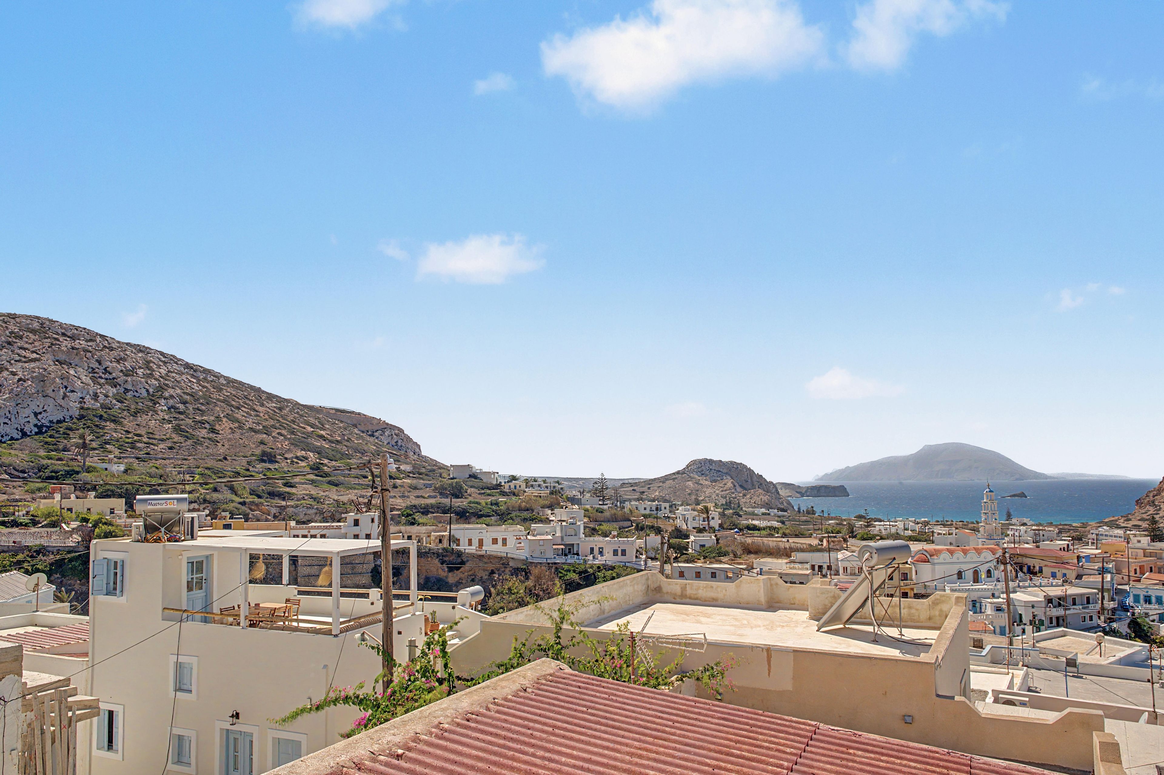A coastal town with buildings, a mountain, and the sea.