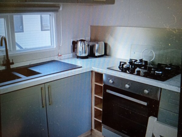A kitchen with a sink, stove, and toaster. - Hedley Wood Park - Duckpool 8 (Holsworthy)