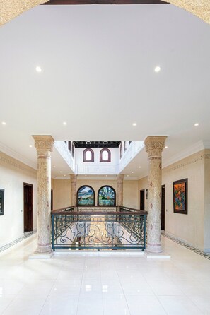 A spacious lobby with a central staircase, ornate columns, and a decorative railing. - Villa Alya | Private Pool | Targa Marrakech (Marrakesh)