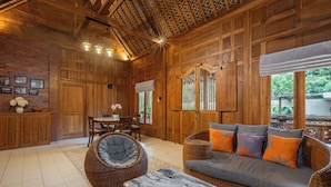 A wooden interior with a sofa, chairs, a table, and a decorative ceiling. - Omah Nyang Uluwatu (Uluwatu)