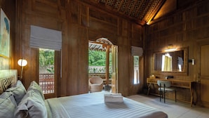 A wooden room with a bed, a desk, a chair, and a mirror. - Omah Nyang Uluwatu (Uluwatu)