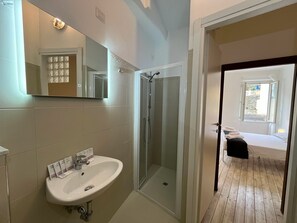 Une salle de bain avec un lavabo, un miroir et une douche.