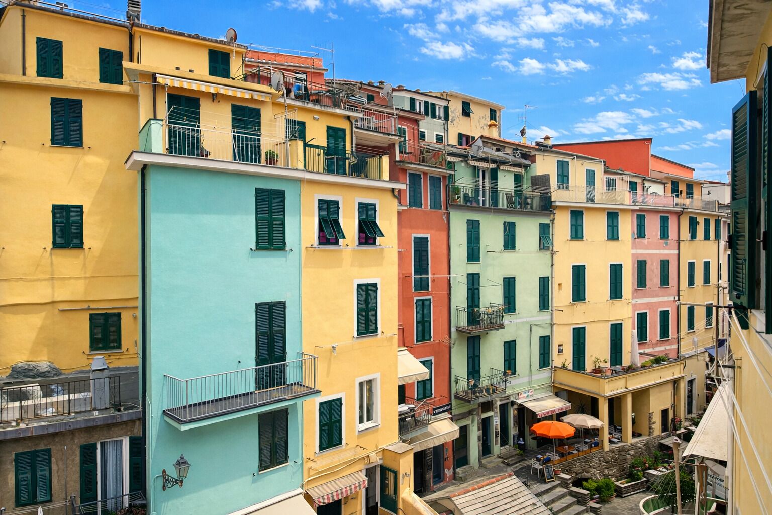 Una hilera de edificios coloridos con balcones y zonas de estar al aire libre.