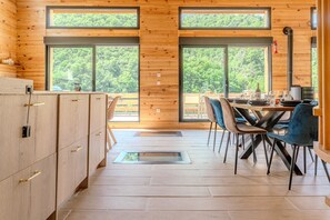 Eine moderne Küche mit Holzschränken und einem Essbereich mit Tisch und Stühlen.