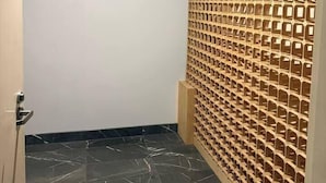 Een kamer met een plafondventilator, een beveiligingscamera, een marmeren vloer en een houten lattenwand.