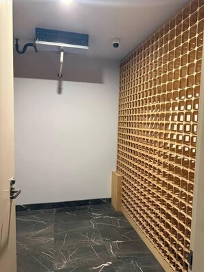 Ein Zimmer mit Deckenventilator, Überwachungskamera, Marmorboden und einer Holzzierwand.