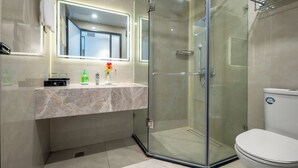A modern bathroom with a glass-enclosed shower, a white toilet, and a marble vanity. - Zhangjiajie New Pipaxi Courtyard Hotel (Zhangjiajie)