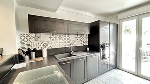 Una cucina moderna con mobili grigi, un lavello capiente e un pannello decorativo.