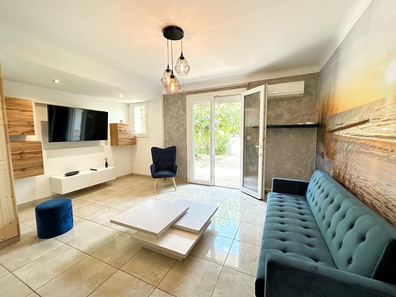 Een moderne woonkamer met een flatscreen televisie, een bank, een salontafel en een fauteuil.