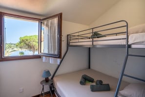 A bunk bed room with a window overlooking a body of water and greenery. - House for 5 people • Swimming Pool • Beach within walking distance • Air Conditioning (Le Barcarès)