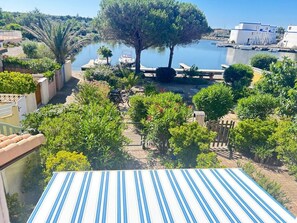 Ett bostadsområde med utsikt över en sjö eller ett annat vattendrag, båtar och träd.