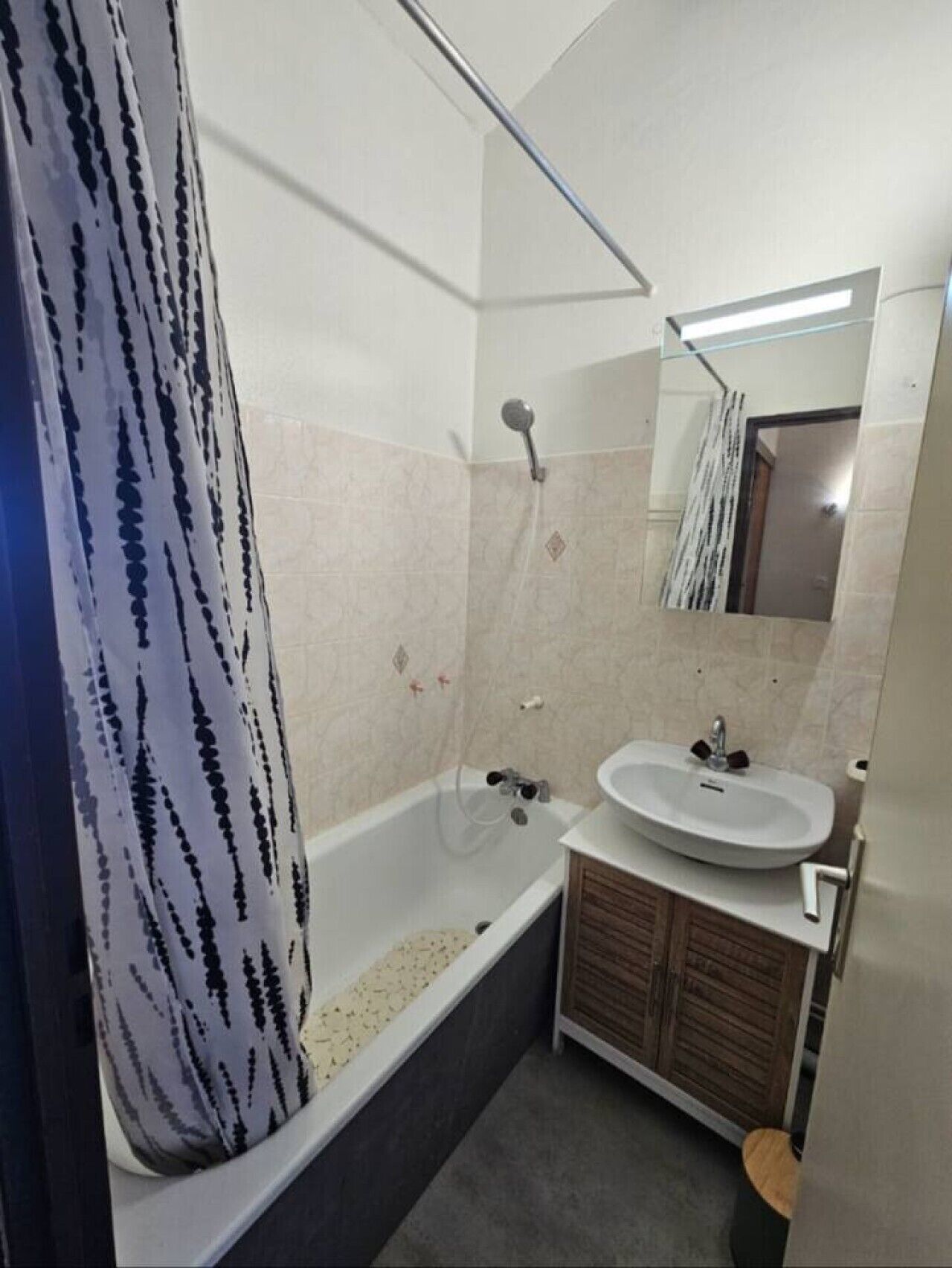 Un baño con bañera, lavamanos y espejo.