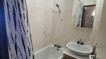 Un baño con bañera, lavamanos y espejo.