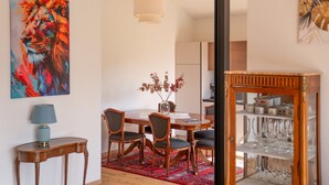 A dining area with a wooden table, chairs, a vase with flowers, and a hanging light fixture. - Vintonia Panorama Apartments I 740A Gleif (Appiano sulla strada del vino)
