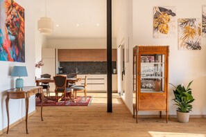 Un ambiente moderno con zona pranzo, cucina e una vetrina contenente bicchieri da vino.