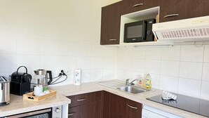 A kitchen with a microwave, toaster, coffee maker, and dishwasher.