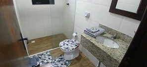 A bathroom with a toilet, a sink, and a shower area. - Apartment for 6 people in the center of Bombinhas with breakfast. (Bombinhas)