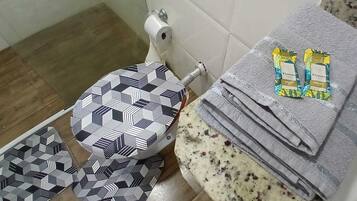 Een douche, handdoeken, zeep, toiletpapier