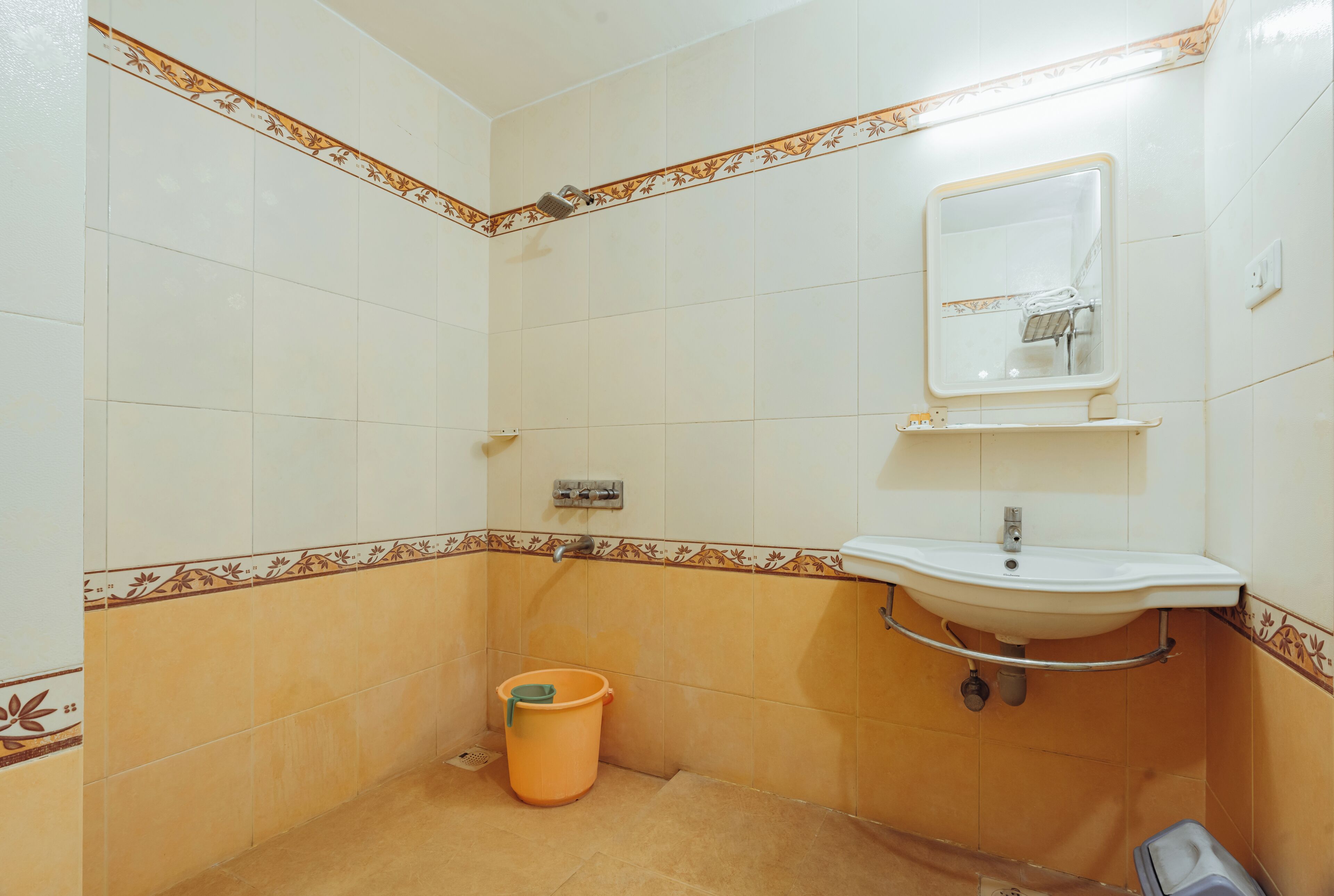 A bathroom with a sink, mirror, and shower.