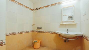 A bathroom with a sink, mirror, and shower.