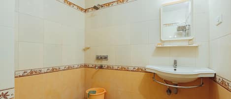 A bathroom with a sink, mirror, and shower.