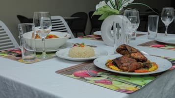 Uma mesa de jantar posta com pratos de comida, copos e talheres.