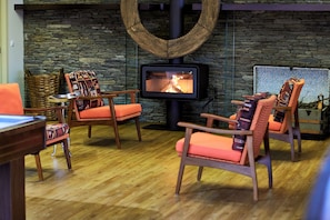 A cozy room with a stone wall, a fireplace, and wooden furniture. - Quinta Rainha Santa Mafalda - Douro Valley Design Villa (Lugar da Posta - Pinhão)