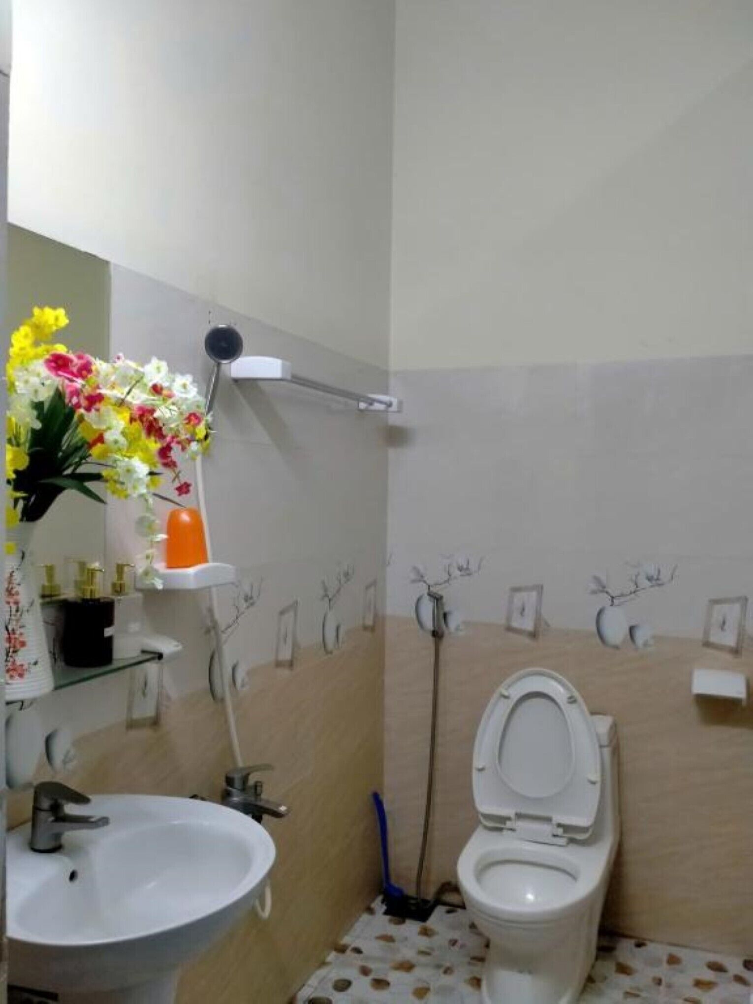 Un baño con inodoro, lavamanos y zona de ducha.