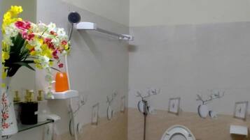 Un baño con inodoro, lavamanos y zona de ducha.