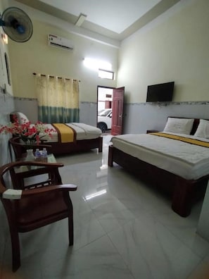Une chambre d’hôtel équipée d’un lit, d’un bureau, d’une chaise, d’une télévision et d’un appareil de climatisation.