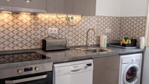 A modern kitchen with built-in appliances, including a dishwasher, oven, and washing machine.
