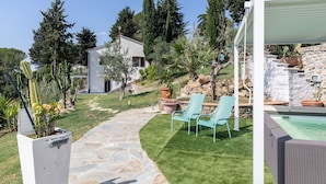 A stone pathway leading to a pool area with outdoor furniture and a white building in the background. - Relais Bellavista, Tuscany (suvereto)