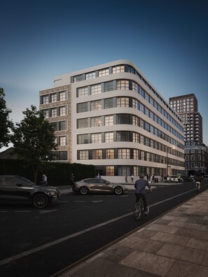 Ein modernes Gebäude mit einer geschwungenen Fassade, mehreren Stockwerken und großen Fenstern.