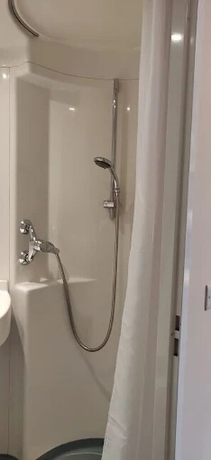 Ein Badezimmer mit Dusche, Waschbecken und Toilette.