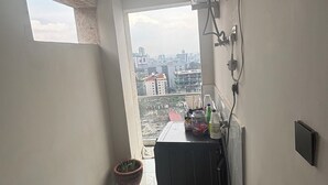 Et aflangt badeværelse med ovenlys, en potteplante og udsigt til bybilledet.