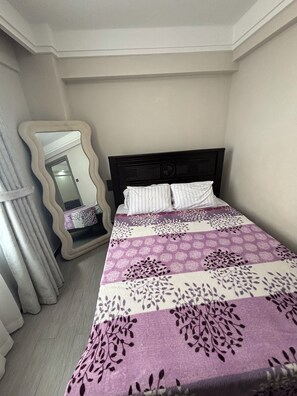 A bedroom with a bed, a mirror, and a window. - Kindaruma Homes, 5 minutes away from yaya centre (Nairobi)