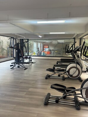 A gym with exercise equipment, large windows, and a wooden floor. - Kindaruma Homes, 5 minutes away from yaya centre (Nairobi)