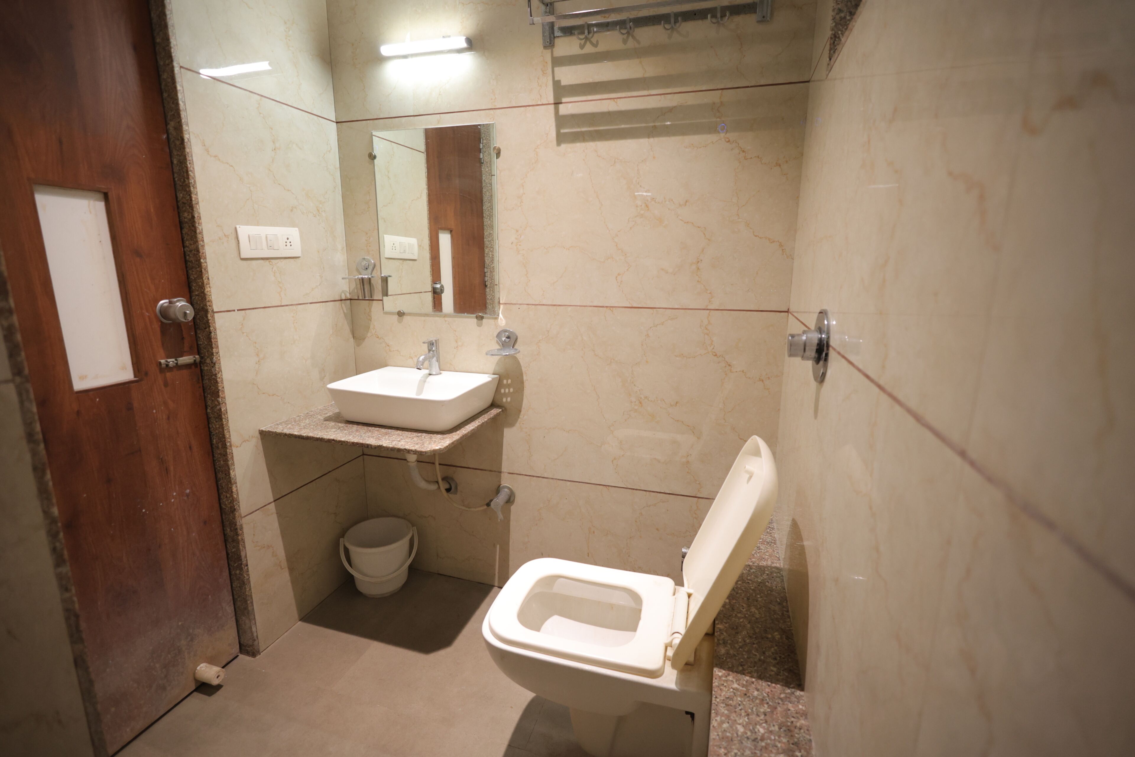 A bathroom with a toilet, sink, and mirror.