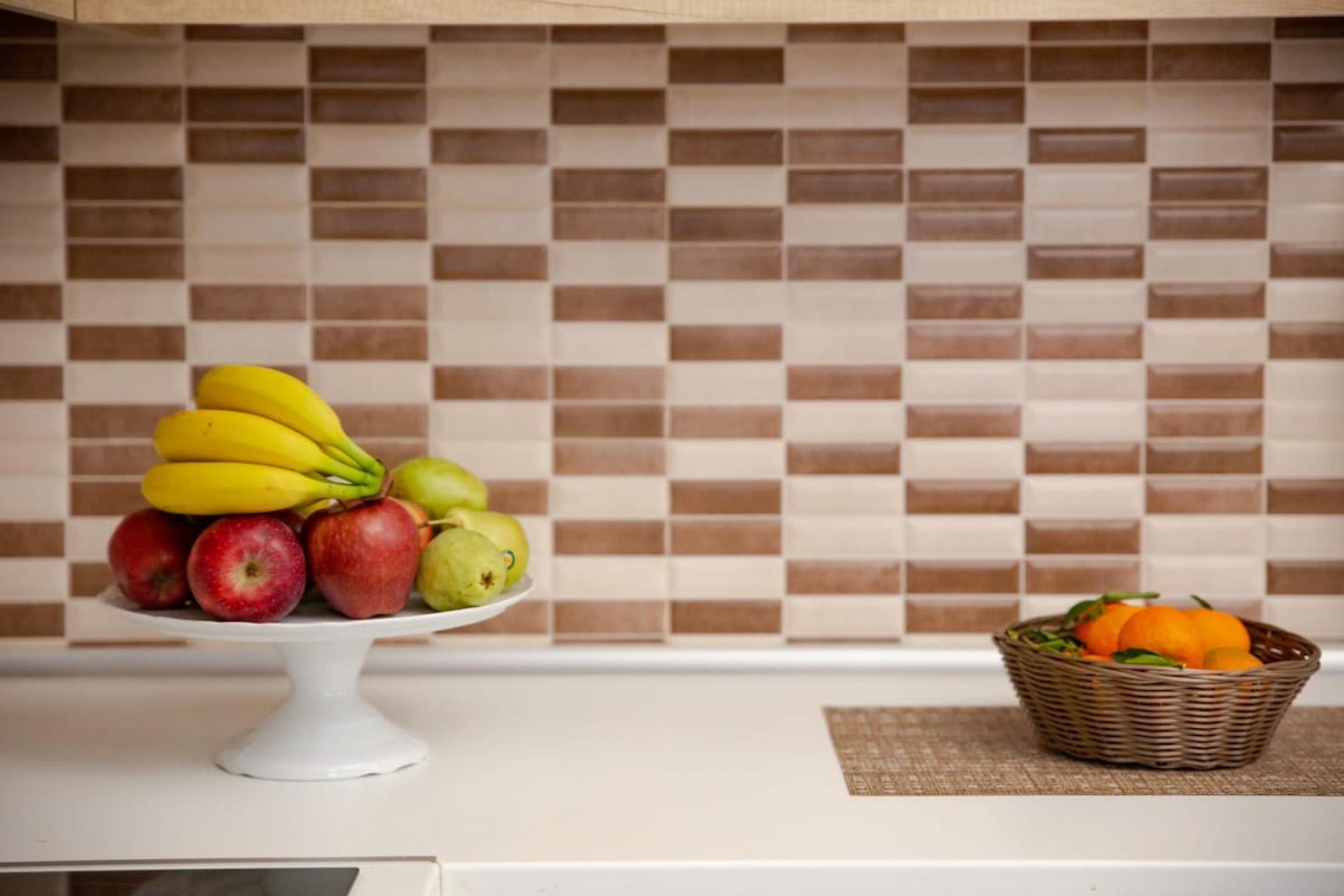 Un comptoir de cuisine avec une présentation de fruits et un panier en osier.