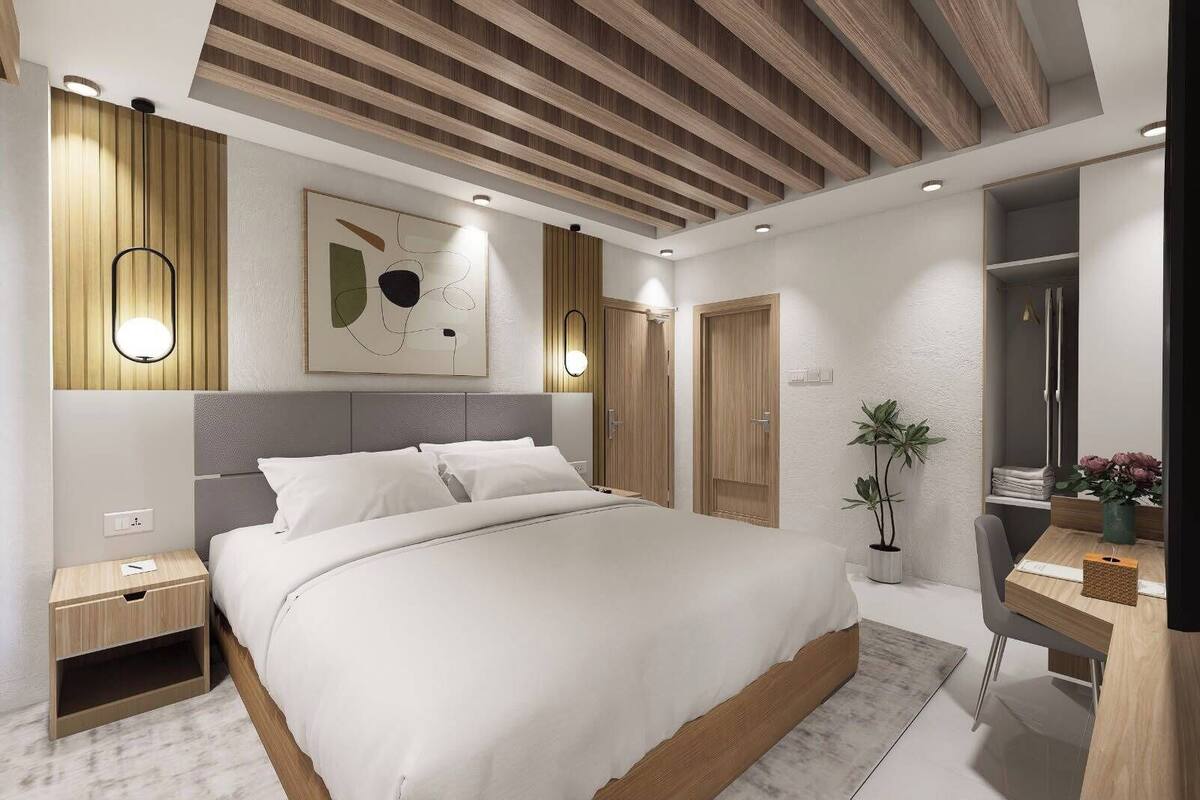 A modern bedroom with a large bed, bedside tables, a desk, and a mirror.