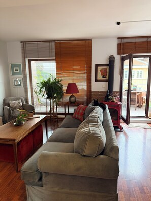 Ein Wohnzimmer mit Sofa, Tisch, Lampe und einer Pflanze.